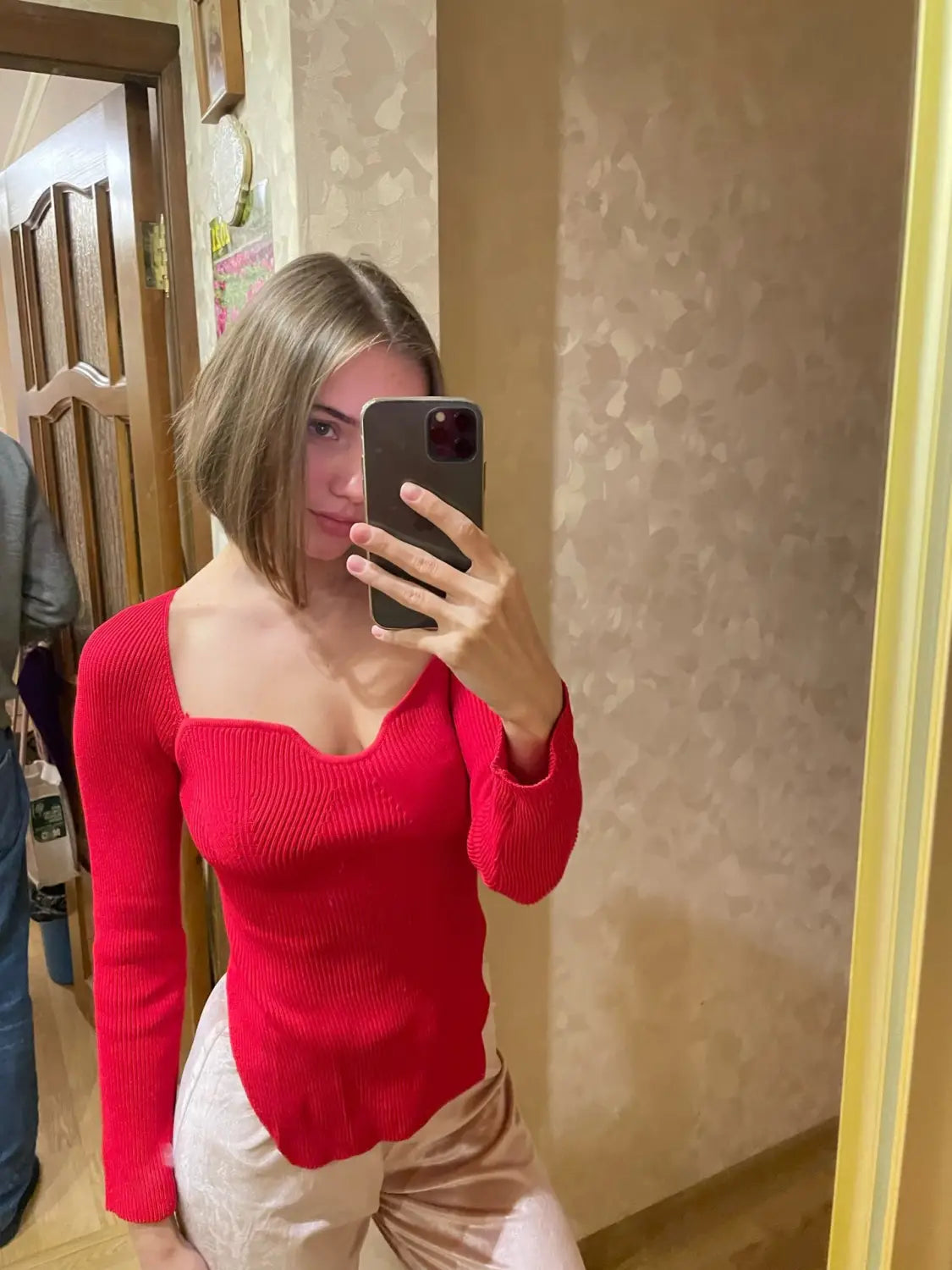 Red ribbed long-sleeved knit pullover with a square neckline and slightly flared hem.