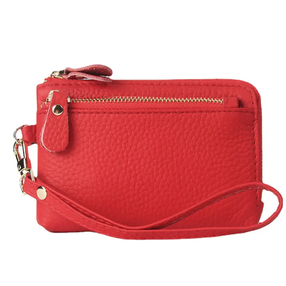 Red pebbled leather wristlet wallet with gold-tone zipper and hardware designed for premium textured leather accessories.