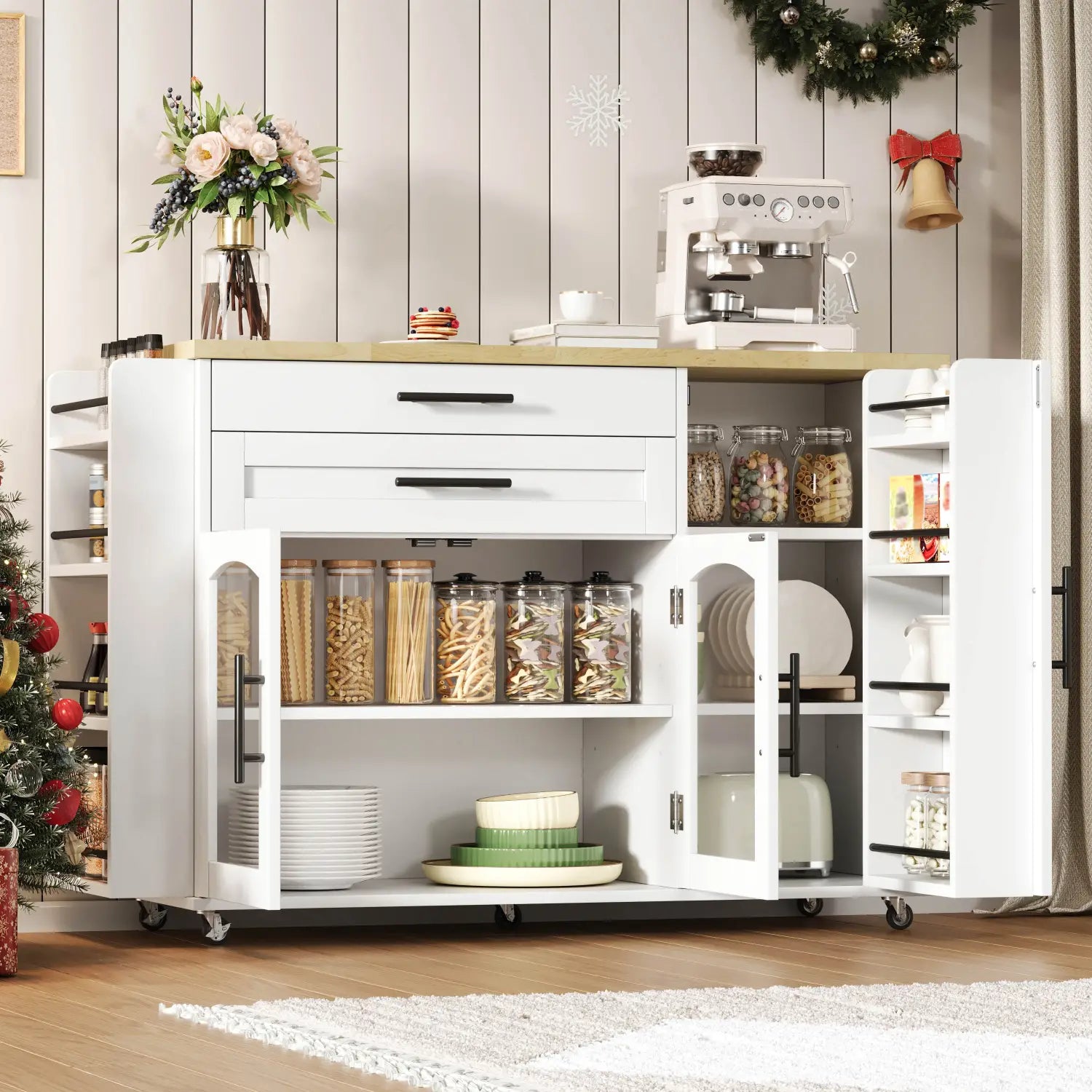 White kitchen cart with wooden countertop and black handles featuring open shelving stocked with glass jars of pasta and plates as a mobile kitchen island with foldable worktop and wheels.