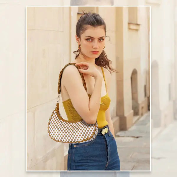 A stylish woven vegan leather checkered hobo shoulder bag featuring a white and brown pattern with braided tan leather straps.