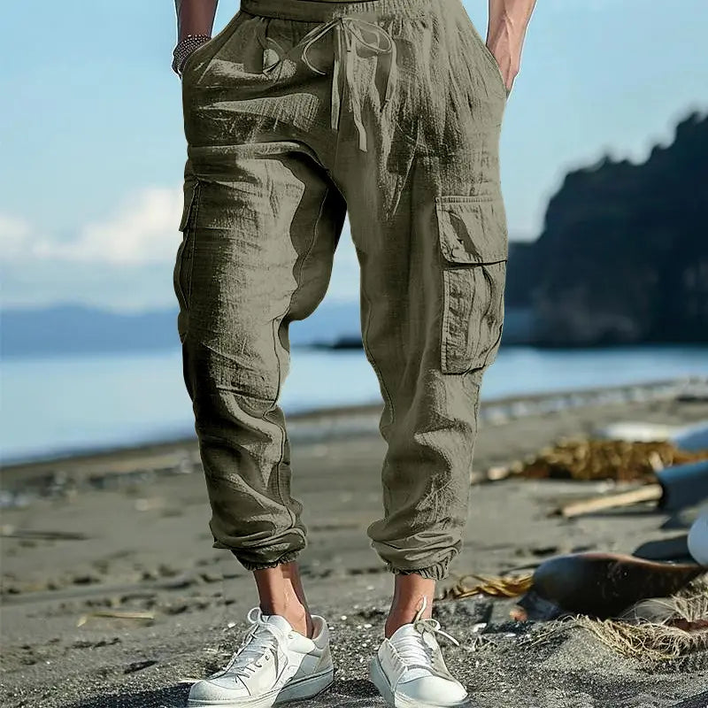 men linen cargo pants in olive green featuring multiple pockets and a drawstring waistband with cuffed ankles