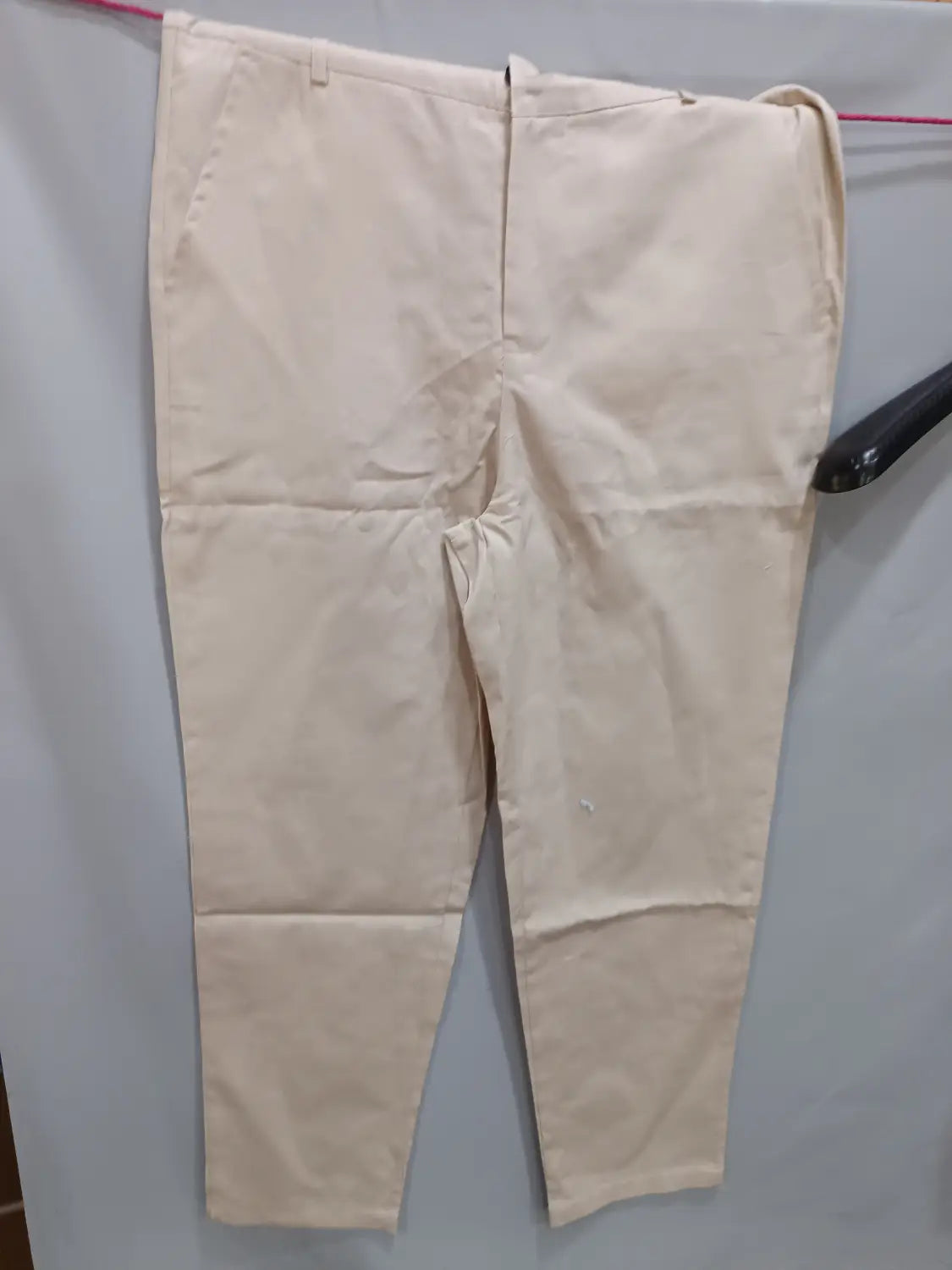 Beige cotton men’s casual slim fit chinos with a classic straight-leg cut and visible front pockets.