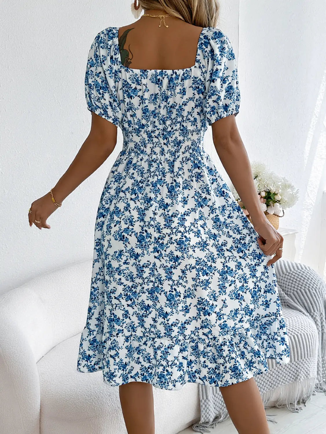 Robe d’été à encolure carrée florale blanche, manches bouffantes à volants, avec un motif floral bleu et manches courtes bouffantes.
