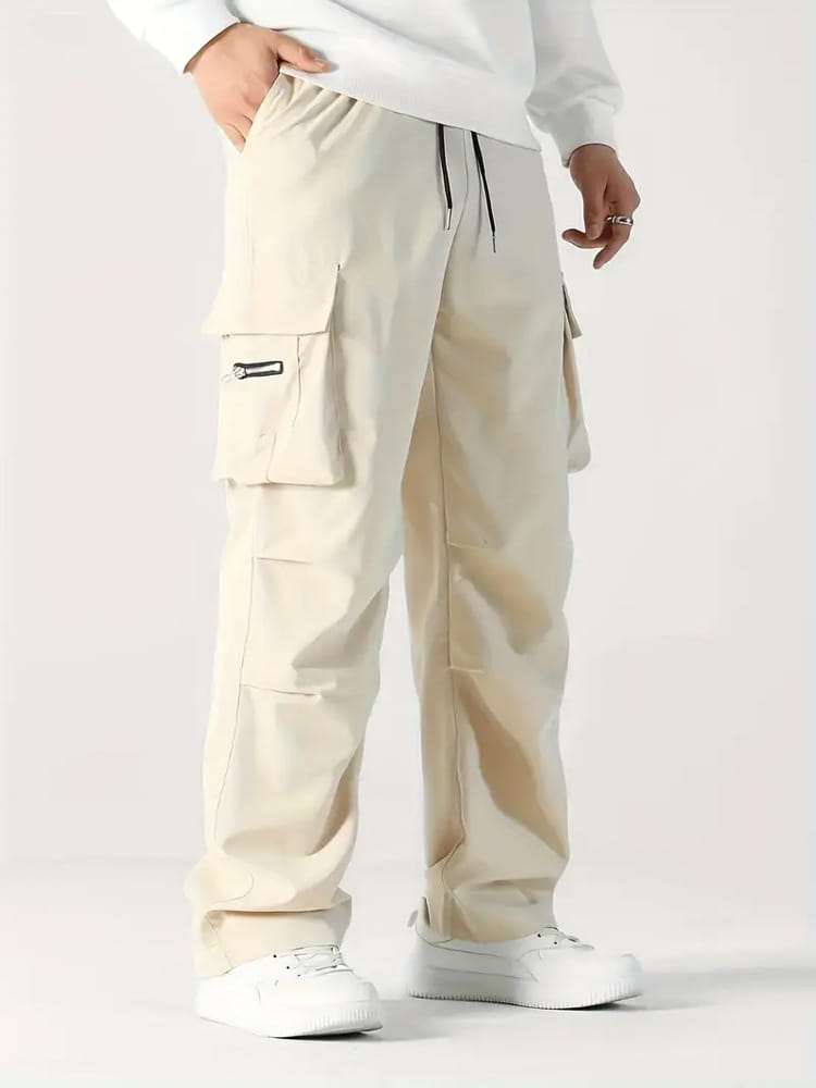 Beige mens multi pocket cargo workwear pants with multiple pockets and a black drawstring waistband.