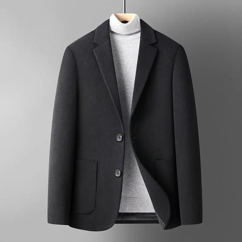 Men’s black wool slim fit blazer with two front buttons and flap pockets worn over a gray turtleneck sweater ideal for winter.