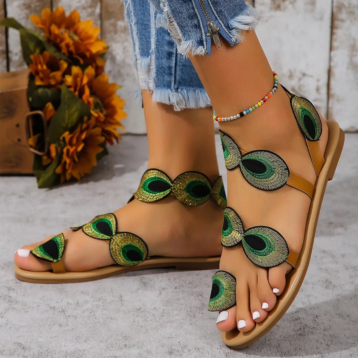 Peacock embroidery flat sandals for women in tan leather featuring green and black peacock-eye embellishments.