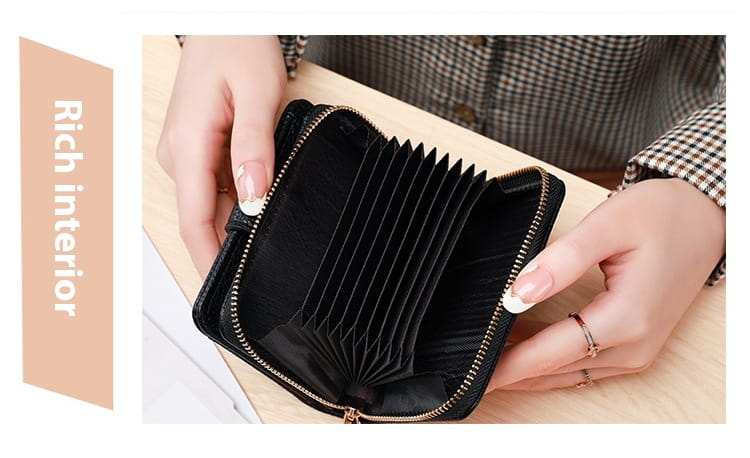 Black leather mini organ wallet with button closure featuring a sleek structured design and gold-toned zipper accents.