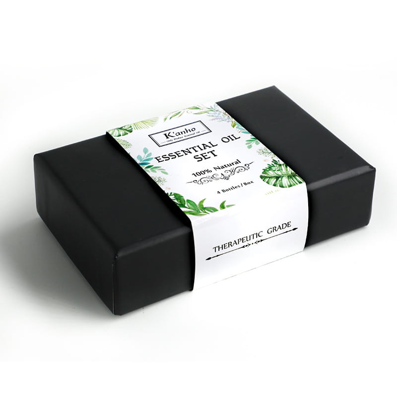 Schwarze rechteckige Schachtel für ein ätherisches-Öl-Set mit weißem Etikett, das grüne Blattmuster zeigt, sowie dem Markennamen kanho für ein Holz-Diffusor-4er-Set.