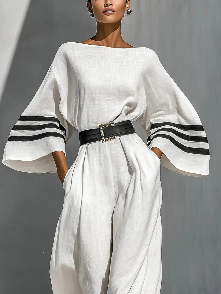 Weißer Leinen-Jumpsuit mit weitem Bein, mit schwarzen gestreiften Manschetten und einem breiten schwarzen Gürtel für einen stilvollen und bequemen Look.