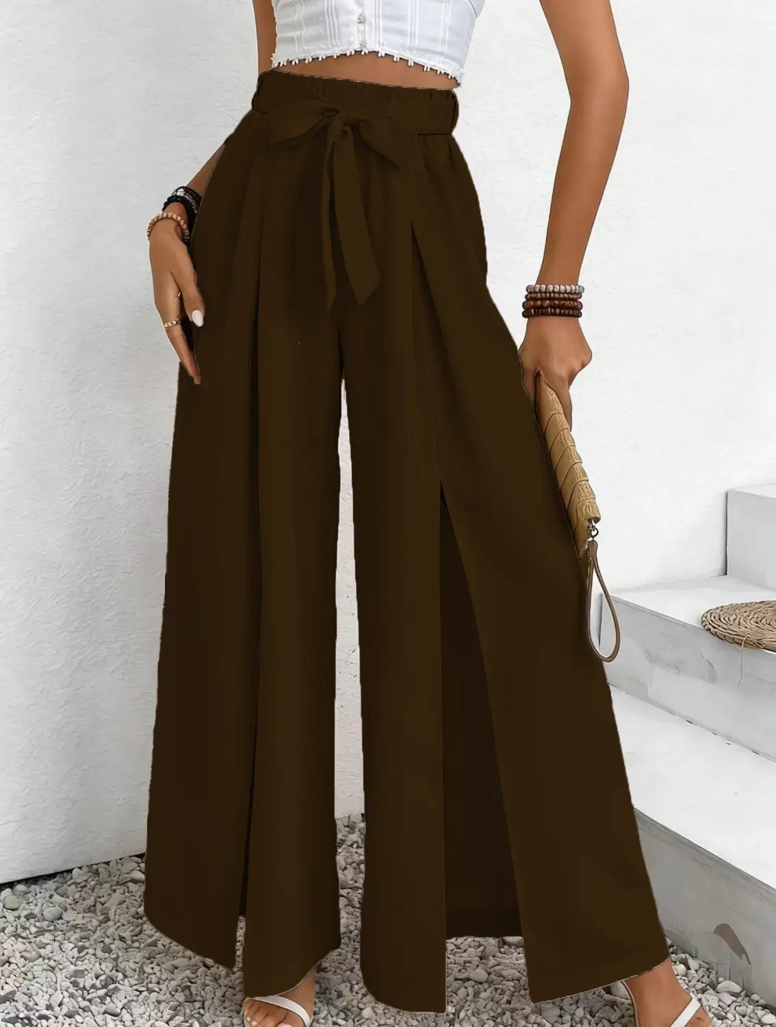 Pantalon ample à taille haute marron, jambe large, avec une ceinture nouée et des fentes latérales, conçu comme un pantalon ample et décontracté