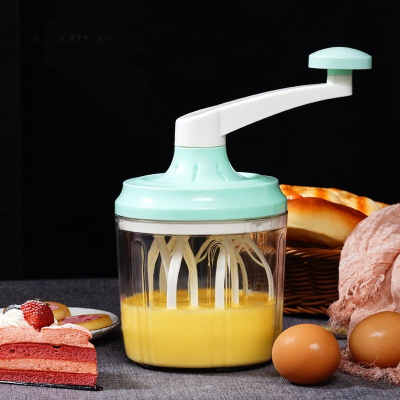 Ein minzgrüner und weißer manueller Handkurbel-Eigquirl und ein 1200-ml-Lebensmittelmixer mit einer klaren Kunststoffschüssel, die gelbe Flüssigkeit enthält.