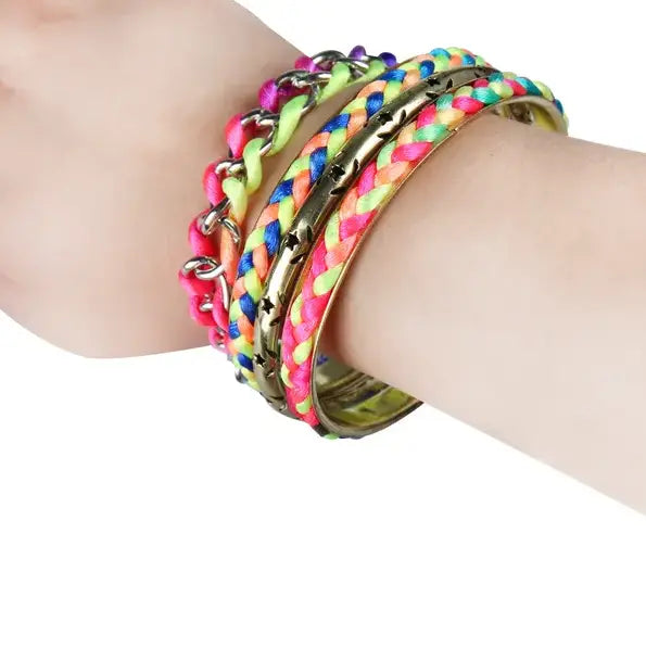 A stack of neon braided cord bracelets in pink yellow and blue with a gold-toned metal bangle featuring star cutouts in a neon braided gold bangle bracelet set with star accents.