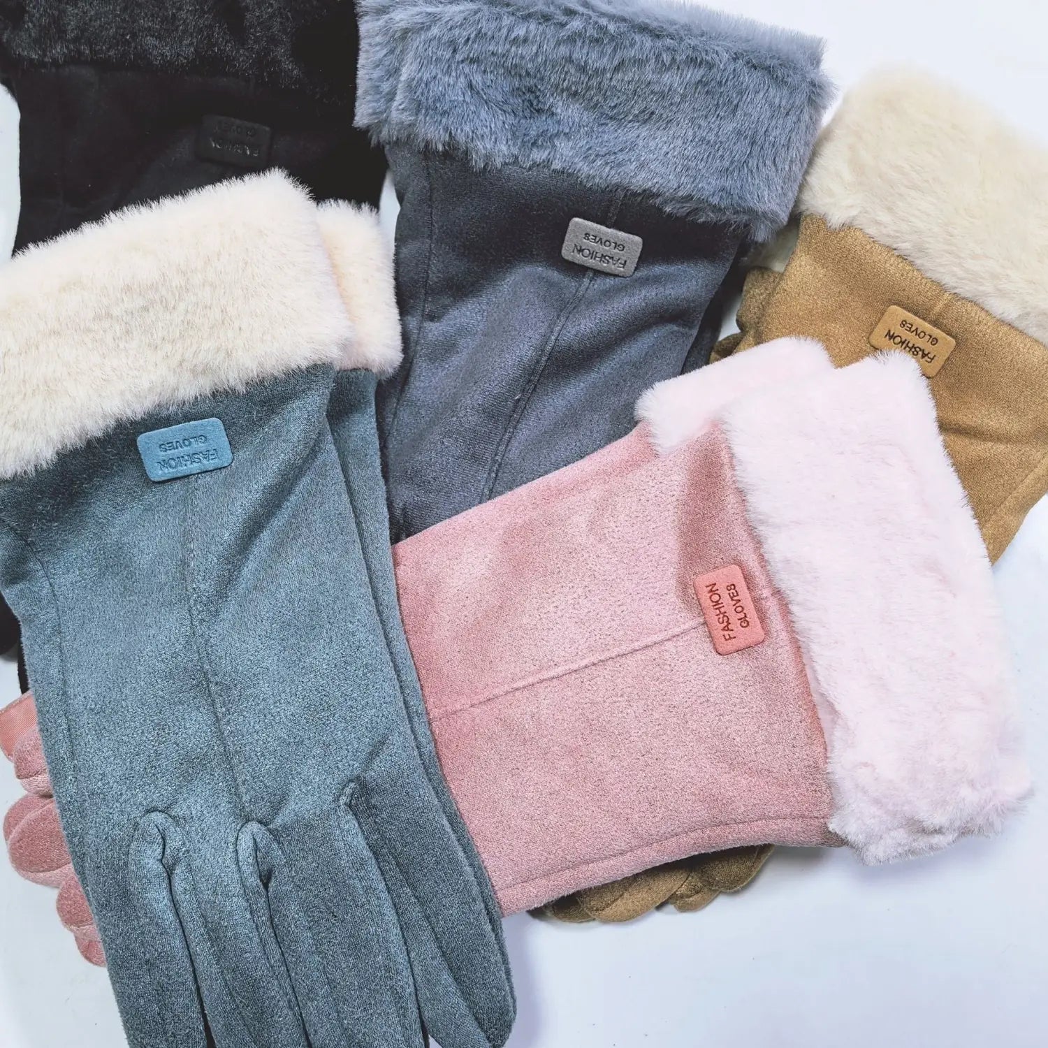 A collection of women’s thermal suede touchscreen gloves with cozy faux fur lining in muted tones of gray pink and beige.
