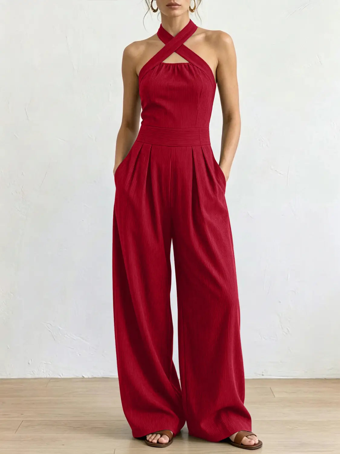 Ein leuchtend roter Halterneck-Jumpsuit mit taillierter Taille und Hosen im weitem Bein, entworfen für stilvolle Anlässe.