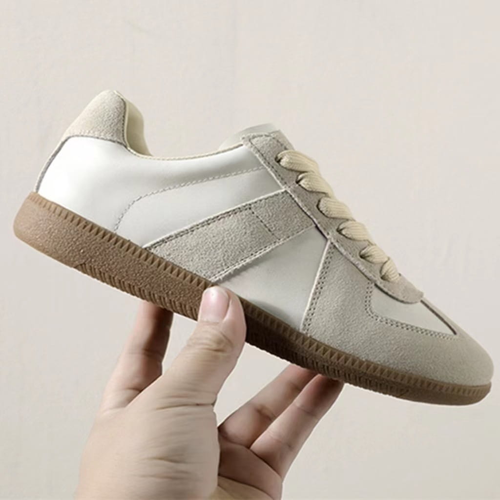 Beige und weiße Veloursleder- und Ledersneaker im Low-Top-Design mit brauner Gummisohle, ausgelegt für vielseitiges, lässiges Tragen.