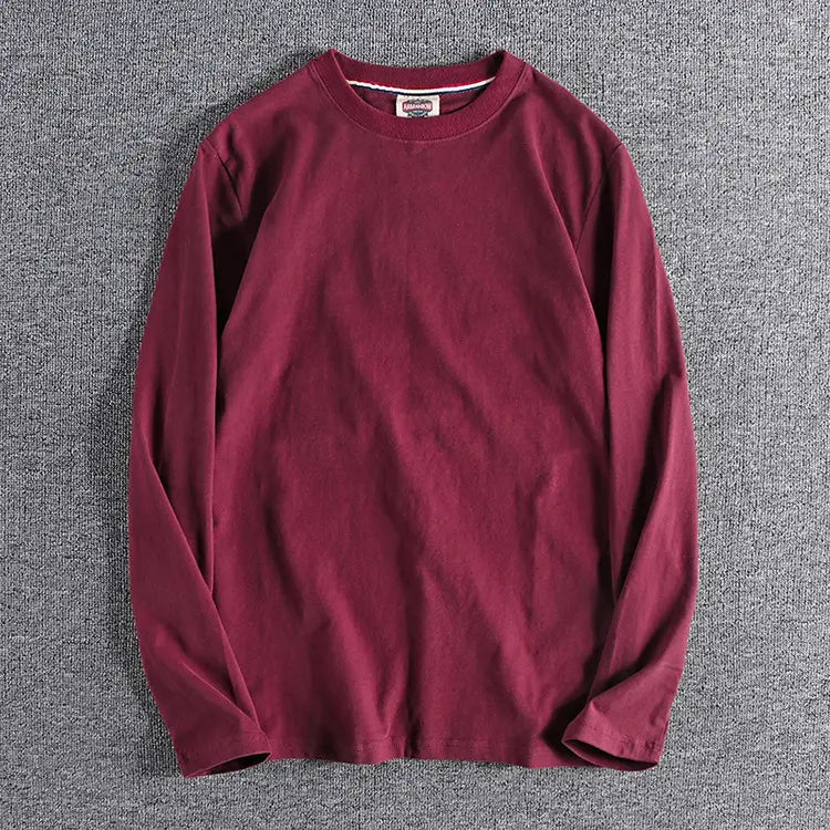 Camiseta de color liso lavado burdeos de manga larga con cuello redondo y textura de tejido suave.