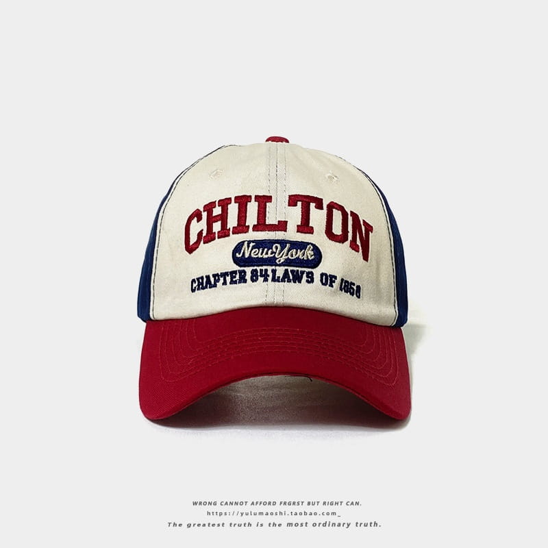 Chapeau de soleil en style vintage, casquette de baseball rétro à empiècements contrastés, avec un panneau avant crème, une visière et des panneaux latéraux rouges, des accents bleu marine, et la broderie « Chilton New York Chapter 84 Laws of 1856 » en rouge foncé, en caractères gras.