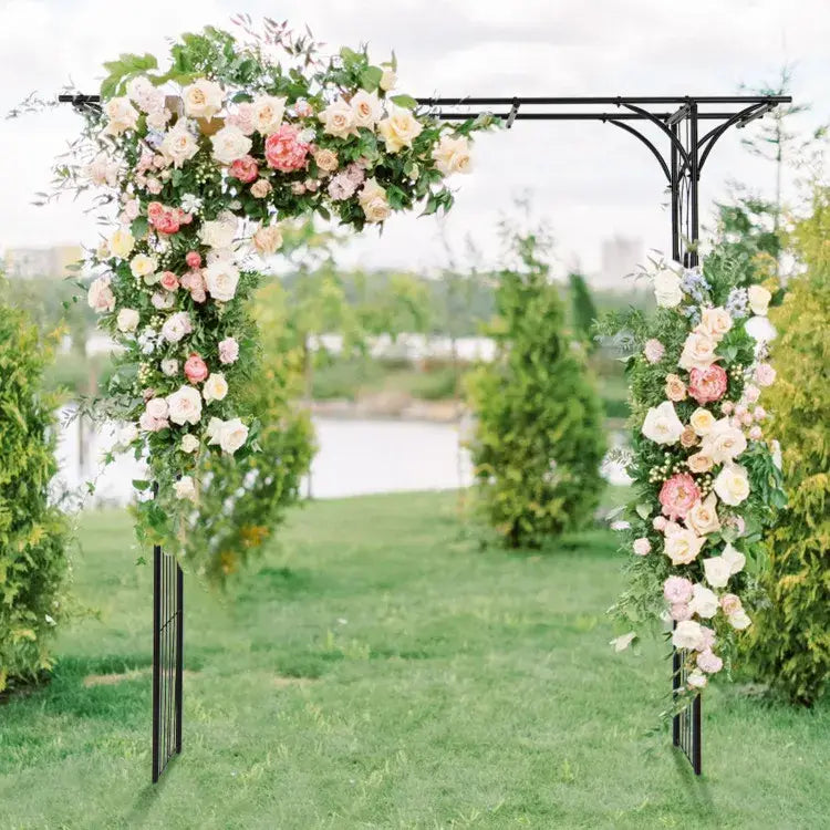 An elegant black wrought iron metal garden arbor archway 81in adorned with cascading pink cream and white roses and lush green foliage for climbing plants.