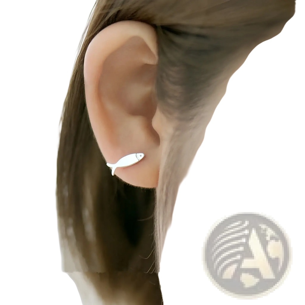 A sleek minimalist silver fish-shaped stud earring made of 925 sterling silver worn on an ear