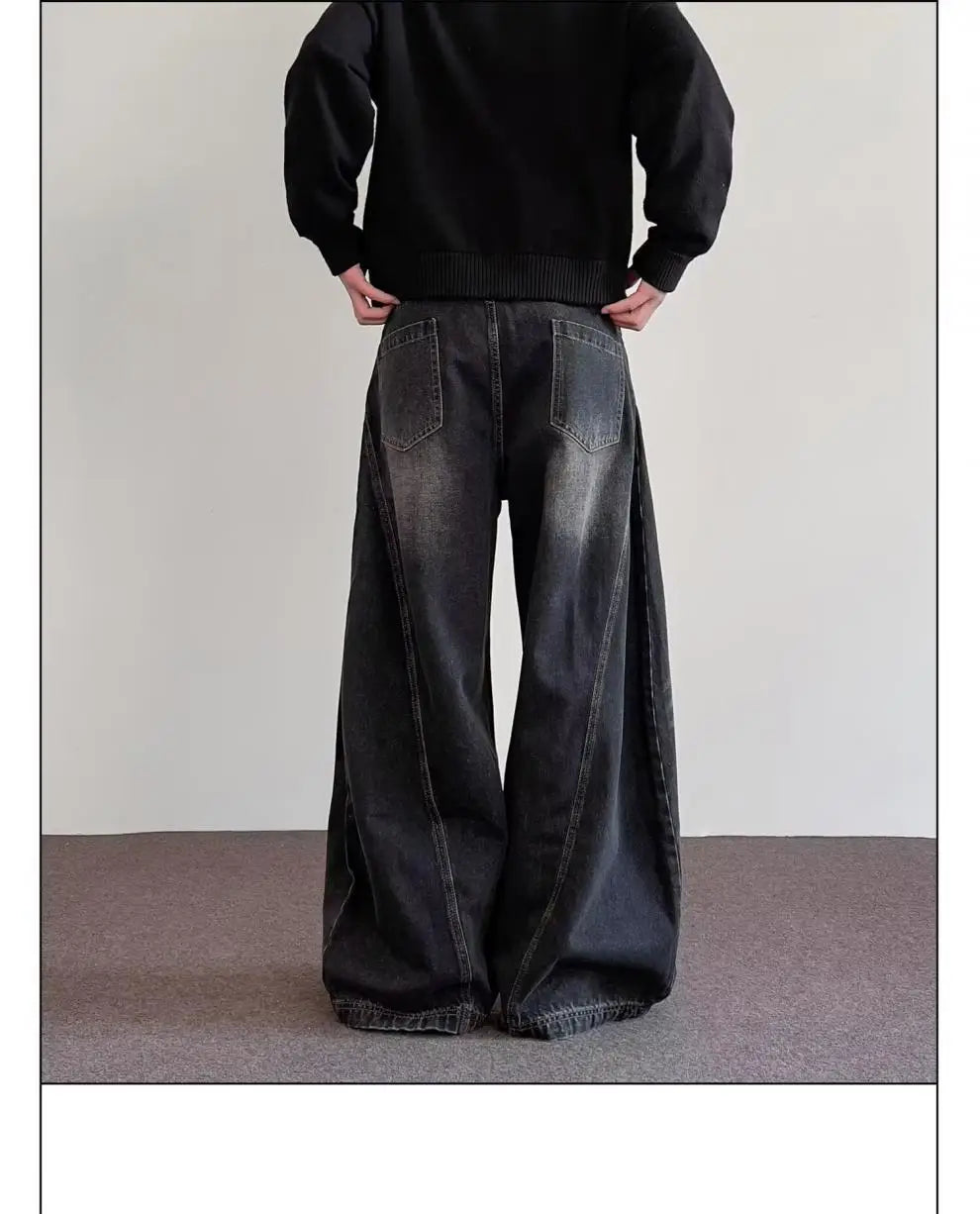 Men’s premium relaxed wide leg denim jeans in black with a faded distressed look and visible stitching made of denim material.