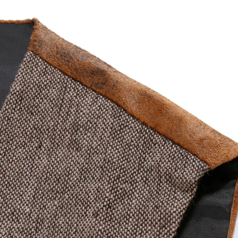 Herren-Tweedweste im Slim-Fit im Business-Casual-Stil aus grauem Tweedstoff mit brauner Lederzierleiste und schwarzem Innenfutter mit einem strukturierten Webmuster.