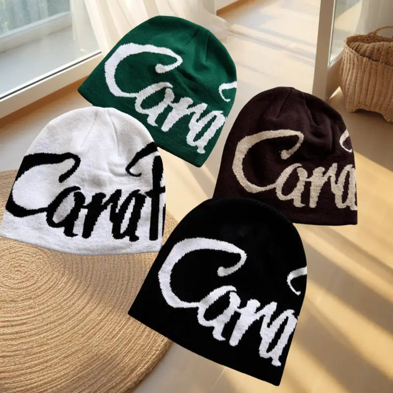 Four knitted beanies in green white brown and black featuring an embroidered cara logo across the front in the embroidered letter knit beanie hat collection.