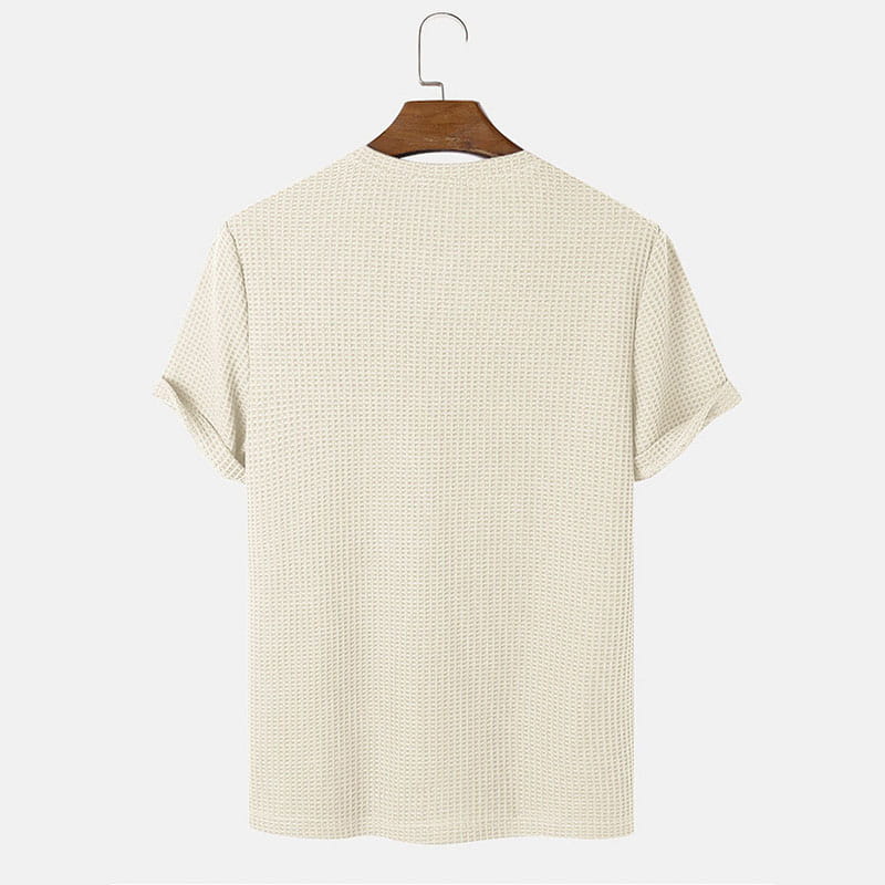 Beiges Herren-T-Shirt in Slim-Fit aus Waffelstrick als Henley mit kurzen Ärmeln, auf einem Holzkleiderbügel hängend.