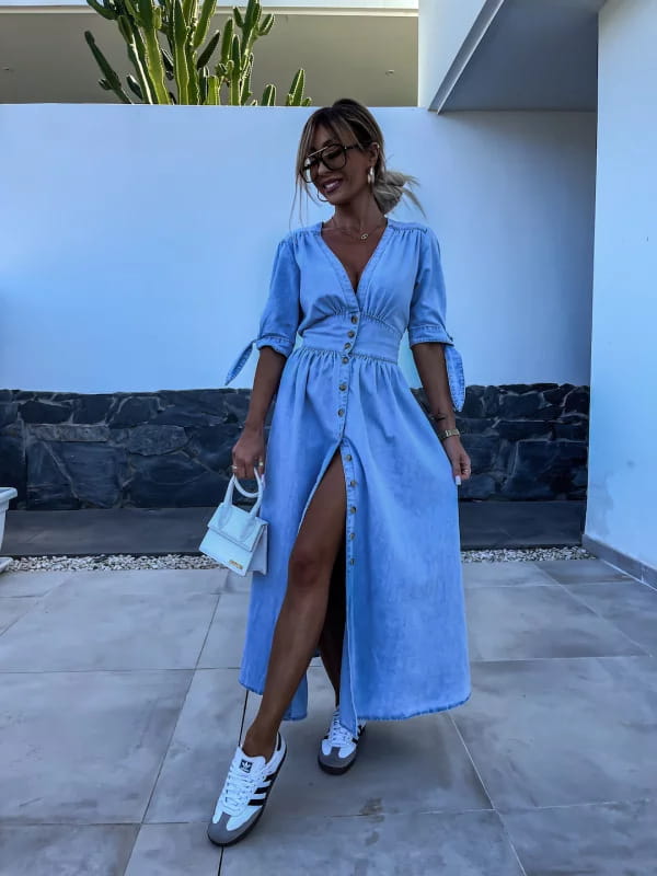 Light blue denim midi dress with button front, puff sleeves, and side slit.