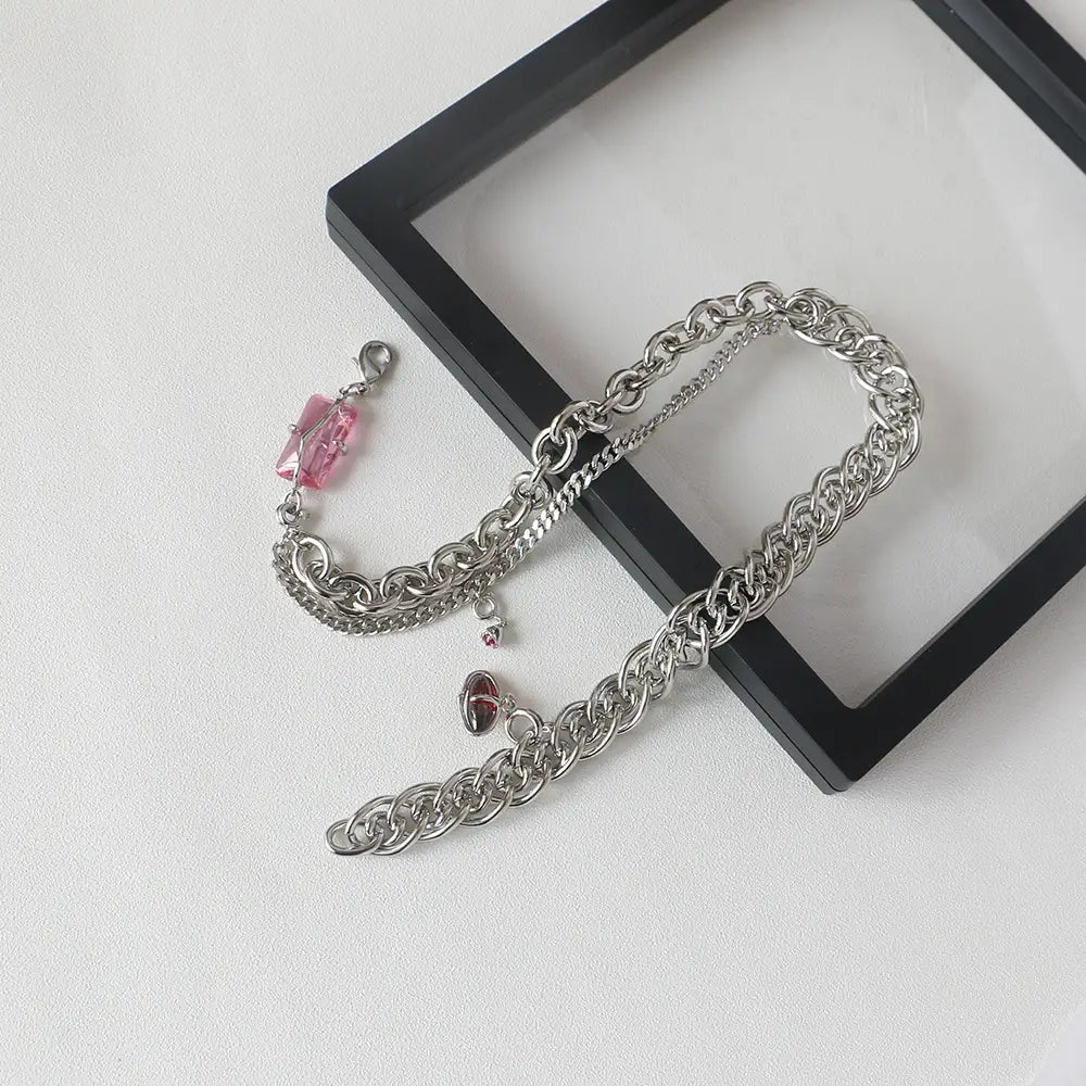 Silver chain belt featuring pink crystal charm and heart pendant complementing a layered silver opal and zircon crystal charm necklace.