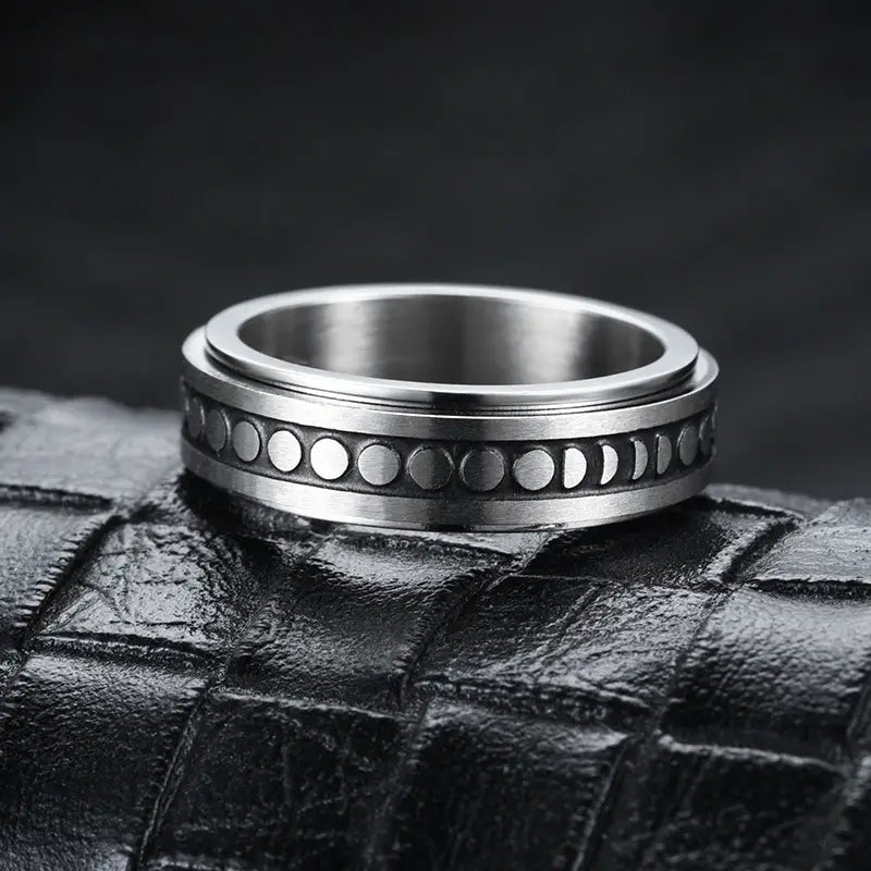 A sleek silver-toned stainless steel spinner ring featuring a detailed engraved band with phases of the moon from the celestial stainless steel anxiety spinner ring set.