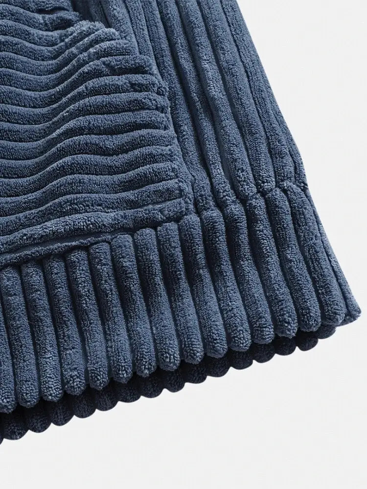 Paillasson de bain en velours côtelé bleu marine avec texture côtelée et surface moelleuse et duveteuse, présenté en même temps qu’un hoodie premium en velours côtelé à épaules tombantes pour hommes.