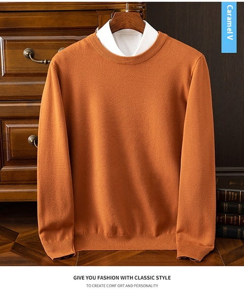 Suéter tipo pulóver de cuello redondo acanalado para hombre en un cálido naranja, con textura de punto suave, usado sobre una camisa con cuello blanco.