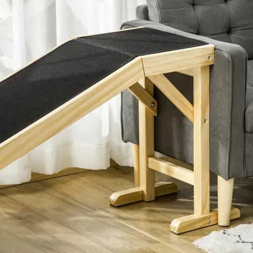 Rampe pour animaux de compagnie en bois avec un cadre en bois clair pour le lit, avec une plateforme en tapis antidérapant noir texturé.