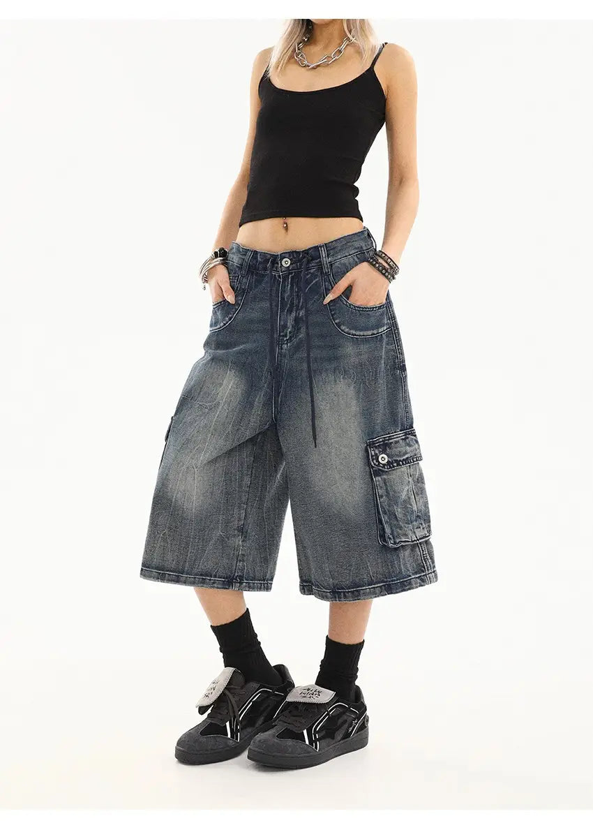 Pantalones cargo de mezclilla azul de pierna recta de estilo urbano, en mezclilla oscura con aspecto desgastado y envejecido, y múltiples bolsillos.