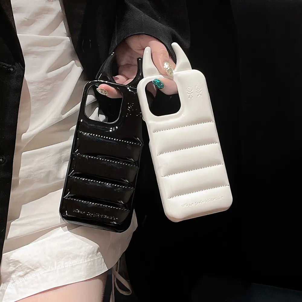 Black and white devil horn quilted leather iPhone cases with a glossy finish and distinctive handle-like cutouts shown from the back side.