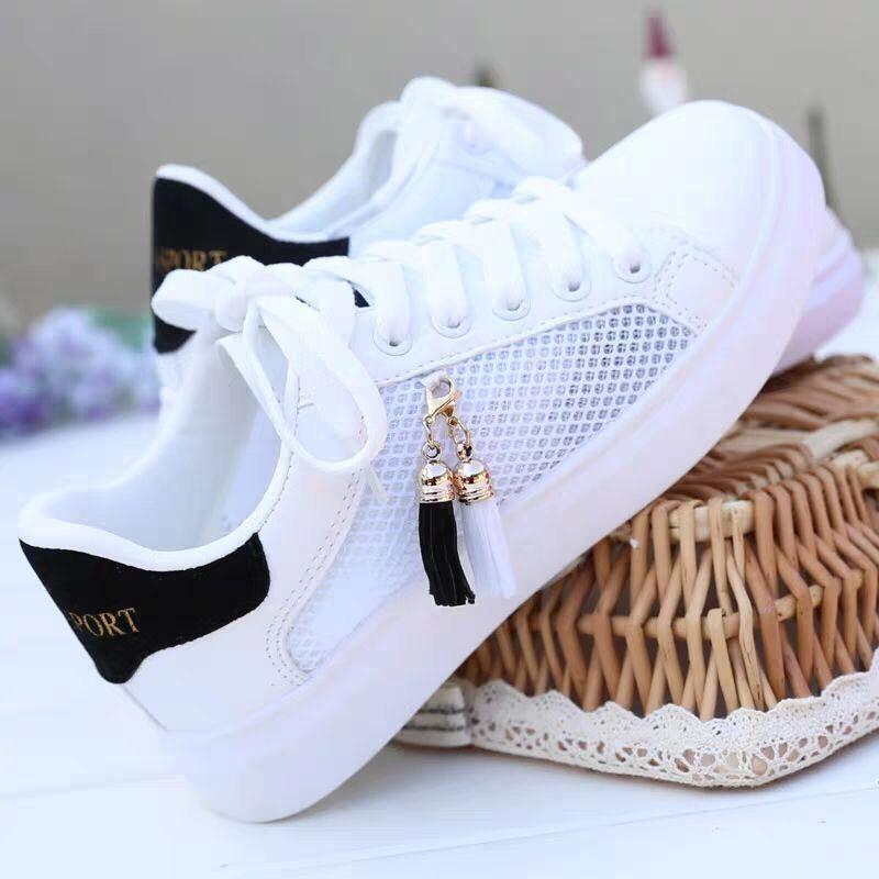 White leather tassel sneakers in white with black accents and a breathable mesh panel featuring gold-toned tassel charms for sports and casual wear.