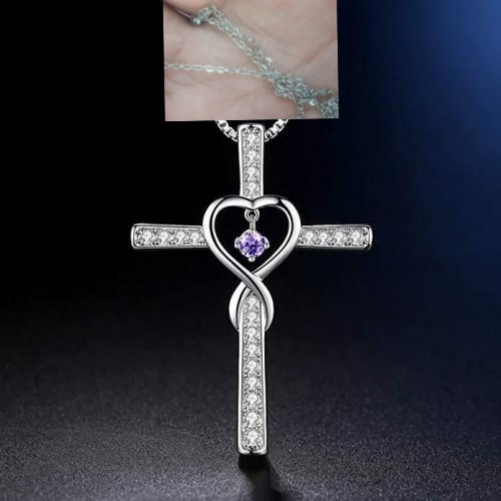 Silver cross pendant necklace with a heart-shaped center featuring a purple birthstone and clear crystals along its arms in the Infinity Love Heart Cross Birthstone Crystal Necklace design.
