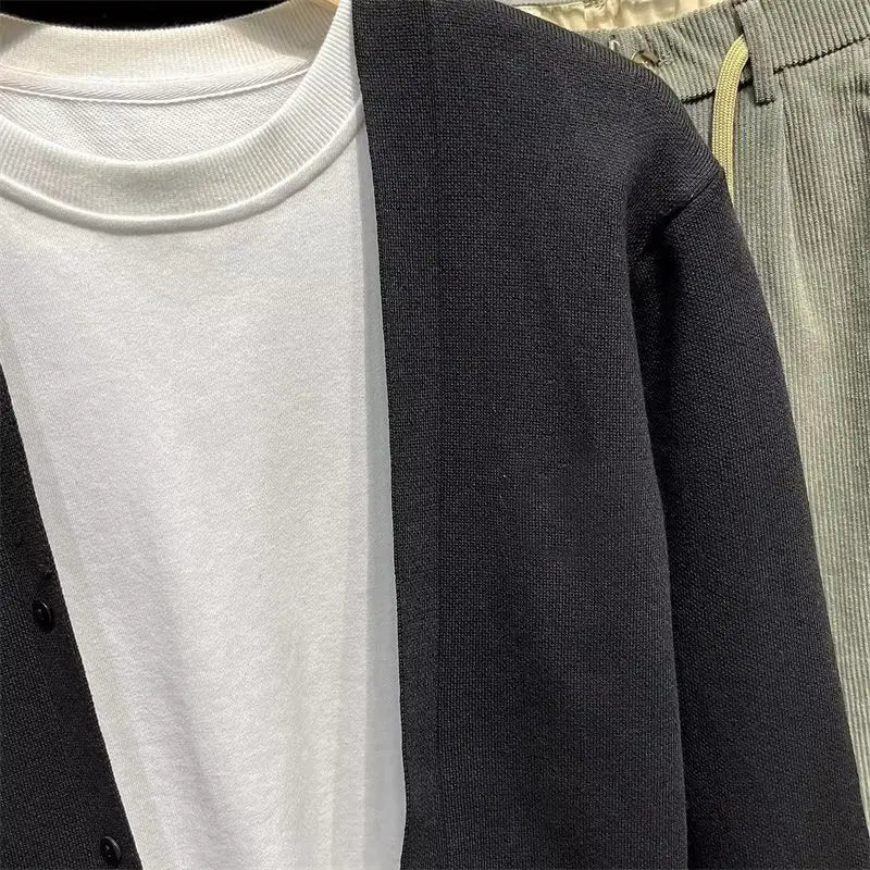 Herren-Strickcardigan in Schwarz und Weiß mit geripptem Rundhalsausschnitt, Knopfverschluss und strukturiertem Stoff.