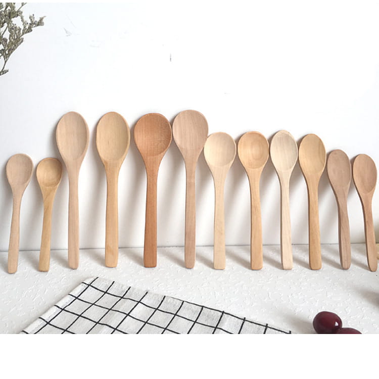 Set of ten natural wood spoons in varying sizes arranged neatly on a white surface showcasing wooden spoon set natural eco-friendly kitchen utensils.