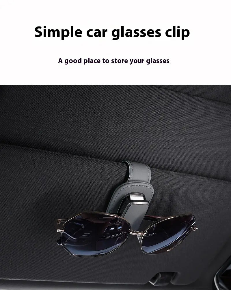 Gray leather car glasses clip holder made of PU leather securely holding a pair of dark-lensed sunglasses.