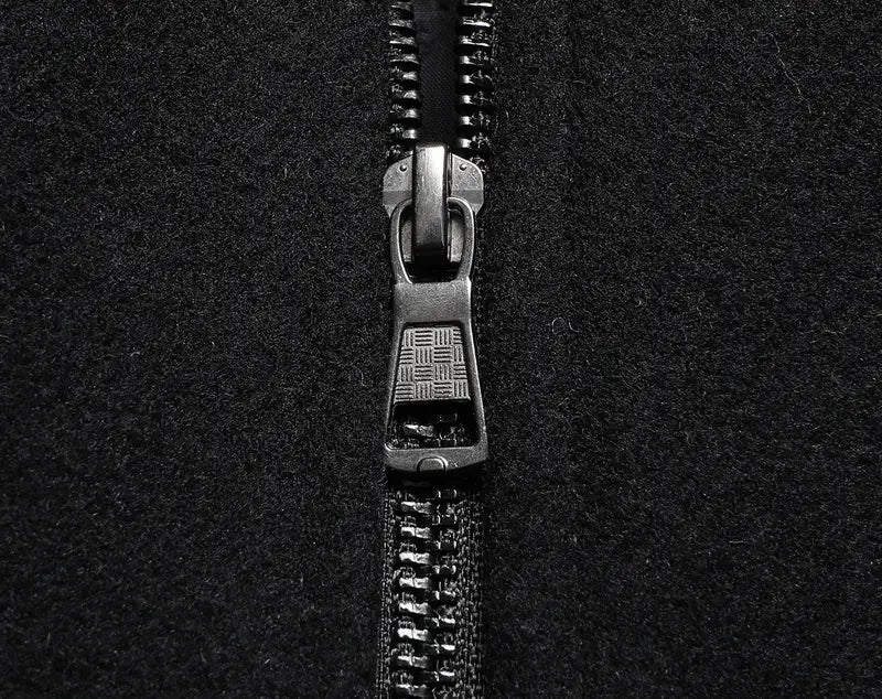 Black metal zipper with textured pull tab on men wool winter overcoat quilted jacket made of dark fabric.