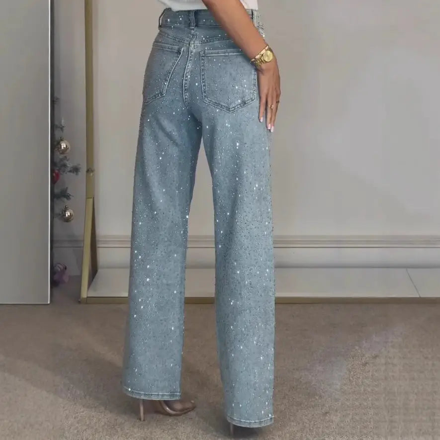 Jeans en denim taille haute à imprimé d’étoiles bleu clair, avec une coupe à jambes larges et des sequins argentés étincelants répartis sur l’ensemble du tissu.
