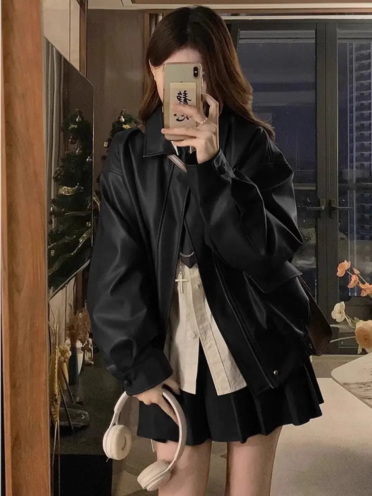 Black faux leather bomber jacket oversized short coat with a relaxed fit and subtle stitching details.