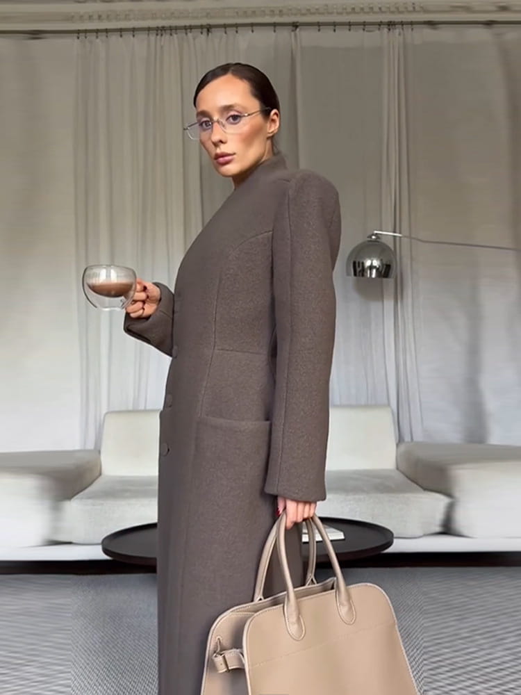 beige leather tote bag with structured handles and minimalist design shown with charcoal gray wool coat women waisted long outerwear
