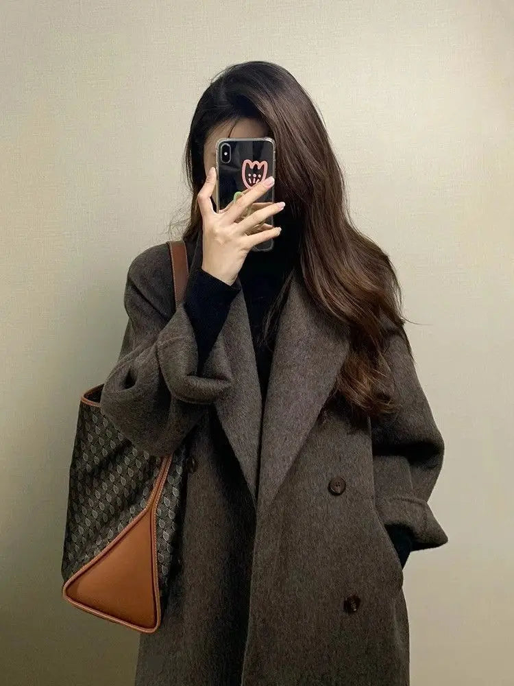 Braune Gucci-Totetasche mit dem charakteristischen Monogramm-Muster und beigem Lederbesatz, die den Damen-Wollmantel mit doppelreihiger Knopfleiste abrundet.