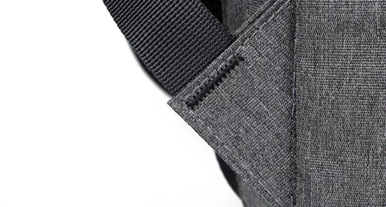 gray textured fabric strap with black woven webbing and matching stitching on the back side of a business laptop backpack with usb charging port made of oxford cloth