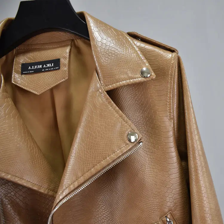 Tan cropped biker jacket made of faux leather with a crocodile skin texture and silver-toned snap buttons featuring a belt.