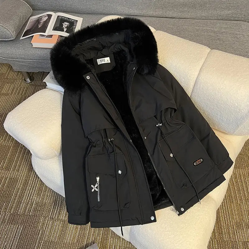 Parka matelassée à capuche avec col de fourrure noire, capuche doublée de fourrure duveteuse, poches avant, avec des tirettes de fermeture décoratives.