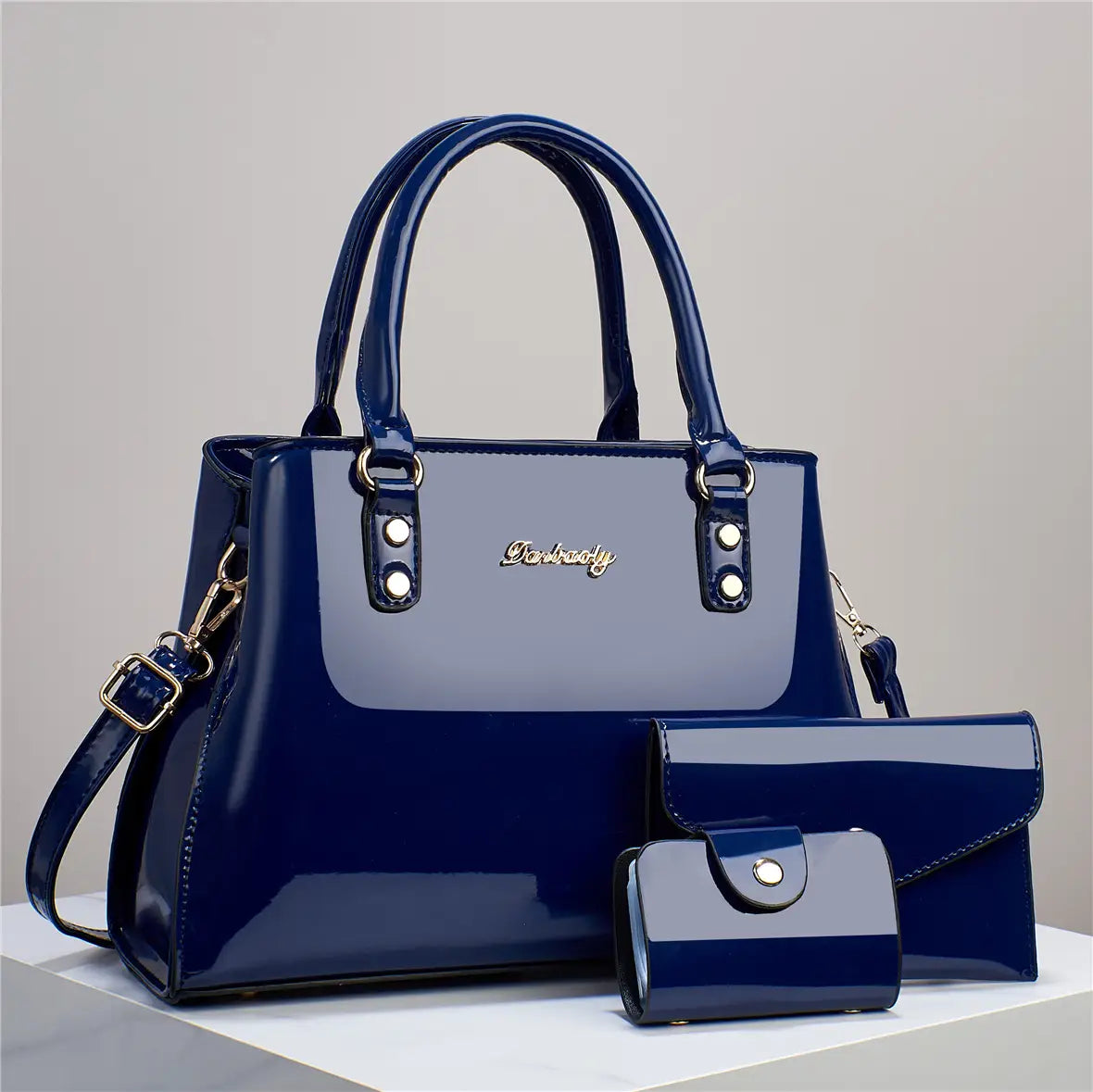 Glossy patent leather 3-piece handbag and wallet set in deep blue featuring a handbag clutch and wallet with gold-tone hardware accents.
