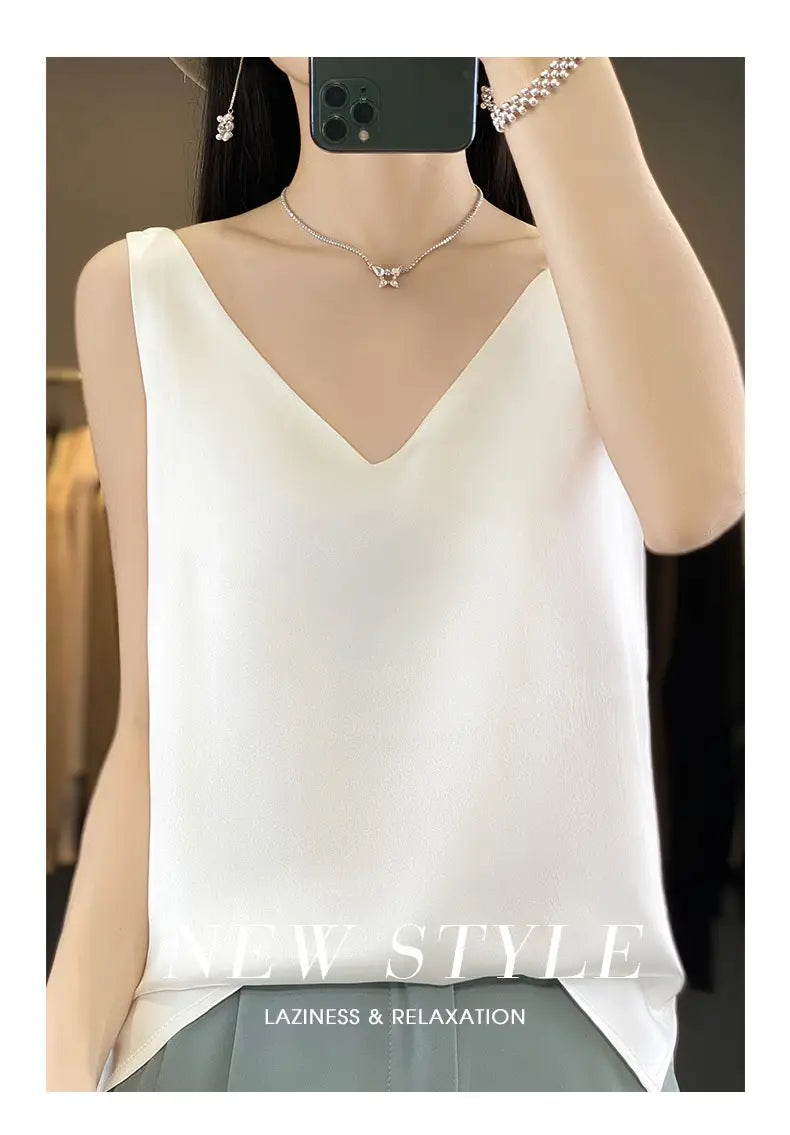 A white sleeveless silky satin v neck camisole top with subtle side slits.